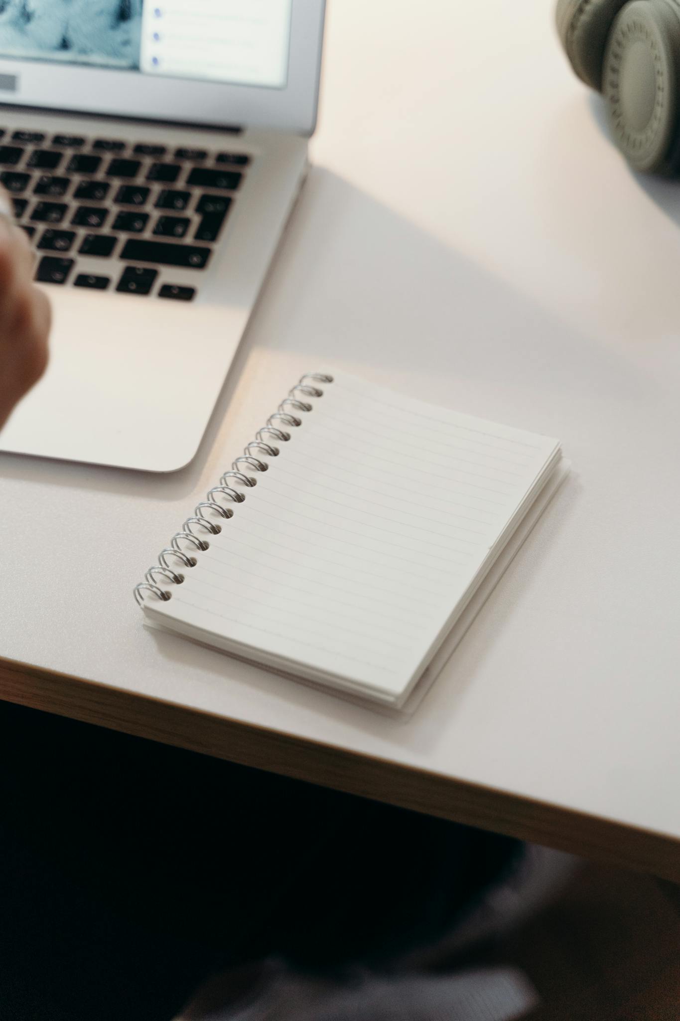 A clean workspace featuring a laptop and a spiral notebook on a desk, perfect for productivity.